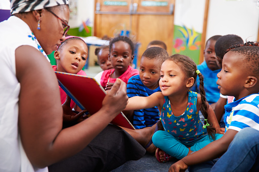 Teacher having story time in class with several young children