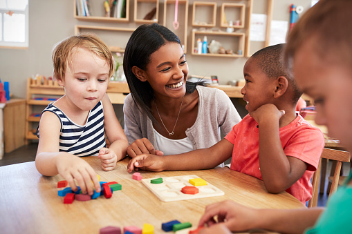 Teacher in her classroom with three young students