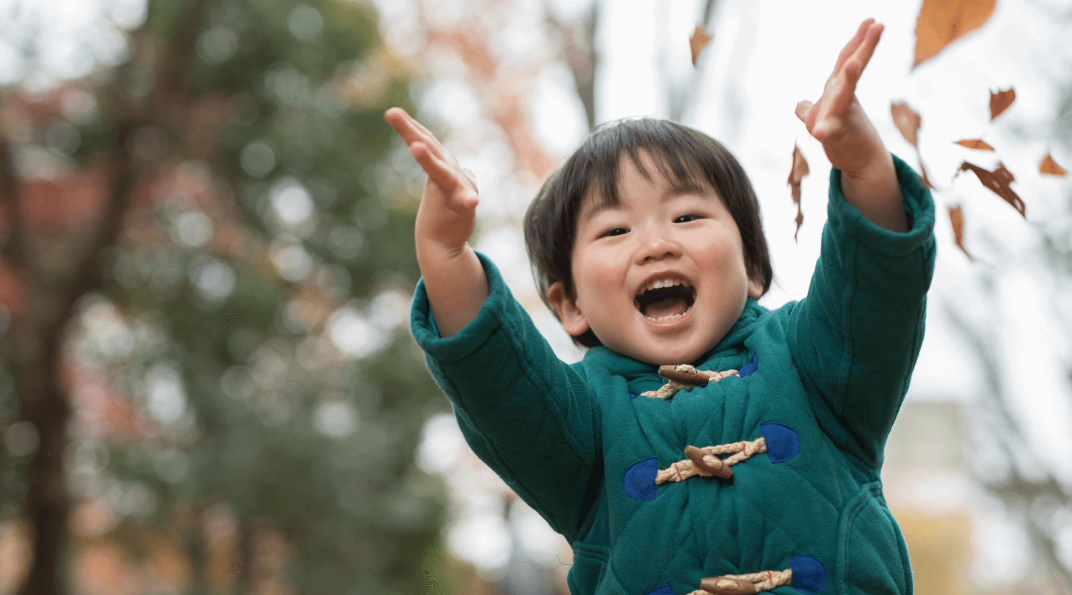 Young child throwing leaves