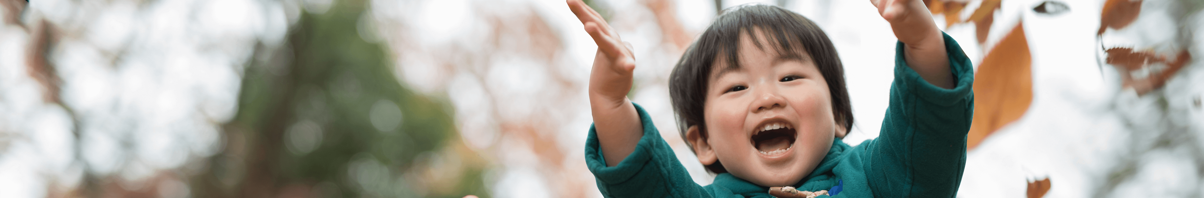 Young child throwing leaves