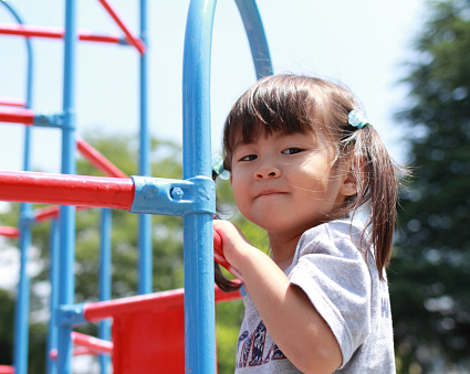Young girl climbing on a jungle gym
